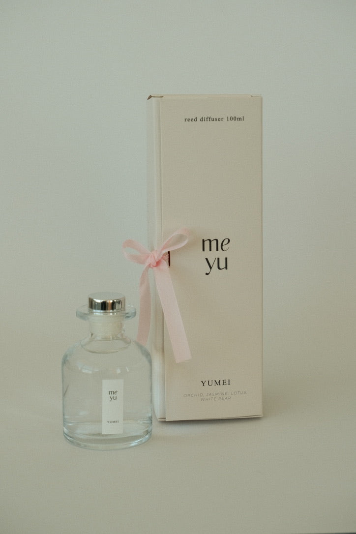 Yumei reed diffuser displayed next to its luxury packaging box with a pink ribbon; home fragrance by Meyu Vancouver, perfect for gifts.