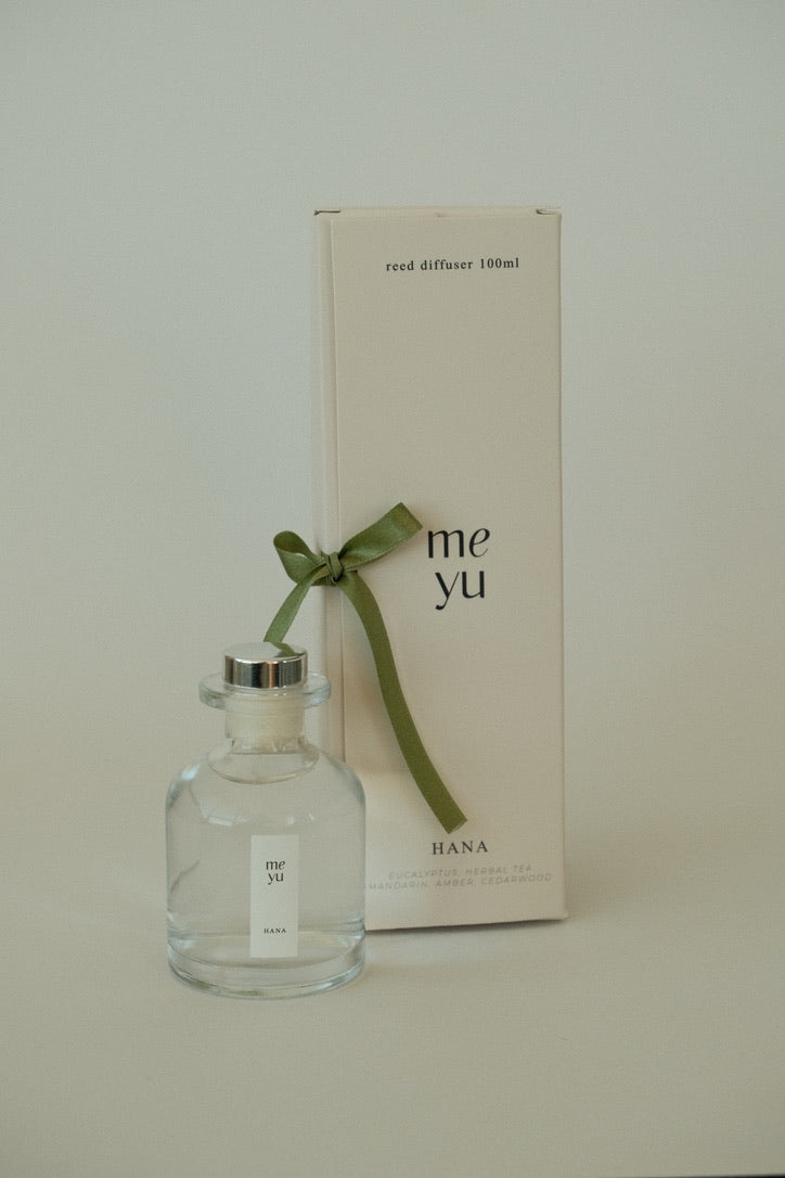 Hana glass reed diffuser displayed next to its luxury packaging box with a green ribbon - home fragrance by Meyu Vancouver