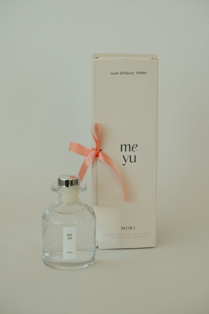 Moki reed diffuser displayed next to its luxury packaging box with a ribbon; home fragrance by Meyu Vancouver, perfect for gifts.